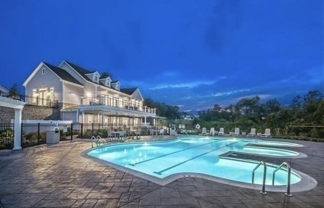 view of swimming pool with a patio area and a hot tub