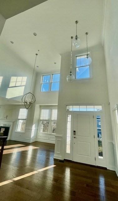 entrance foyer with a towering ceiling, dark hardwood / wood-style floors, and an inviting chandelier