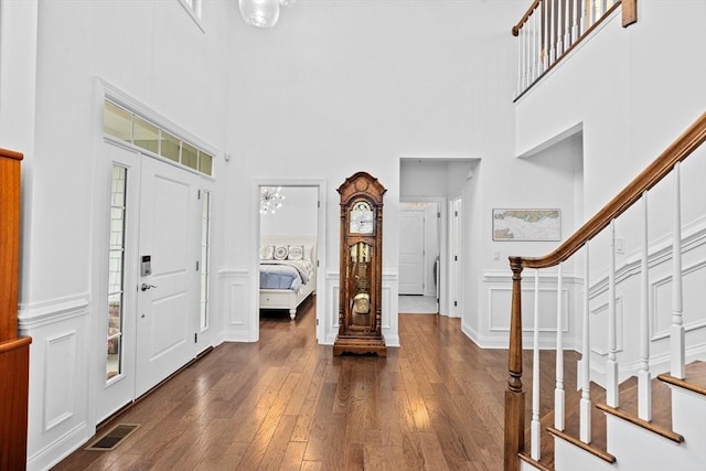 entryway with dark hardwood / wood-style flooring and a high ceiling