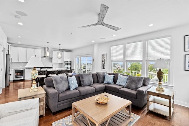 living room featuring ceiling fan, dark wood-type flooring, and beverage cooler