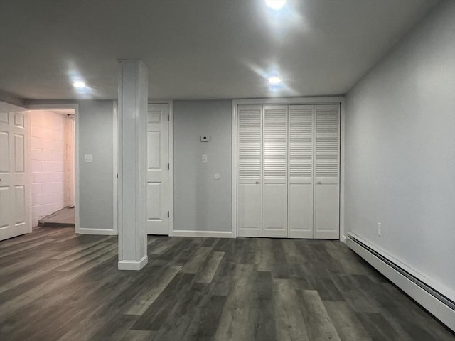 basement with a baseboard radiator and dark hardwood / wood-style floors