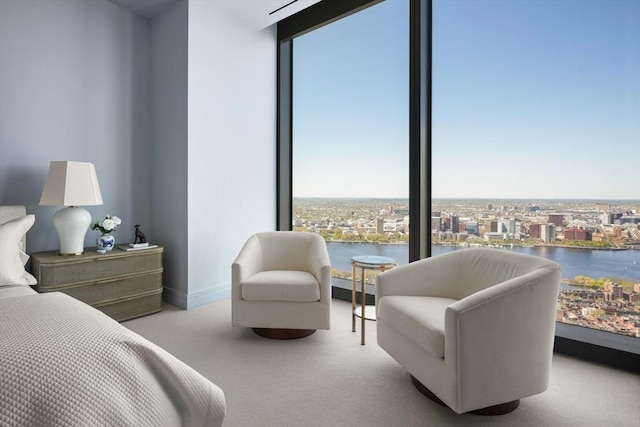 carpeted bedroom featuring multiple windows, expansive windows, and a water view