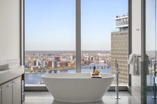 bathroom featuring a soaking tub, a city view, and a water view