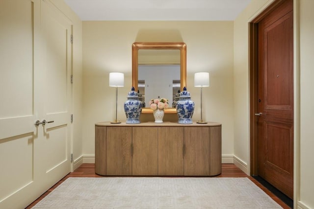 hall with baseboards and wood finished floors