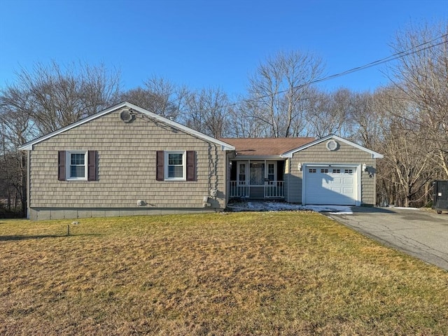 ranch-style home with a garage, a front lawn, and covered porch