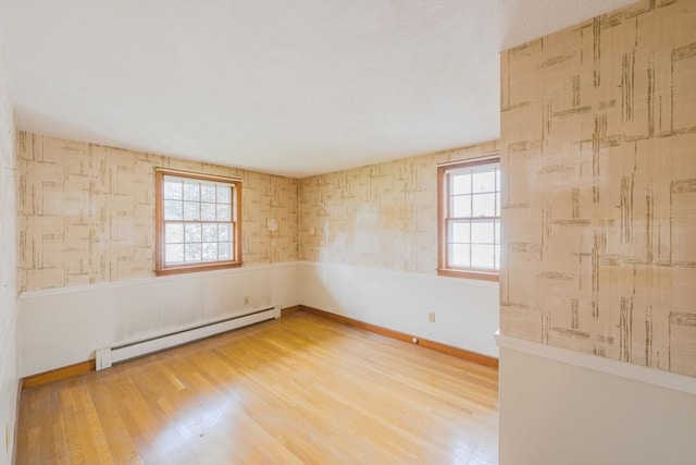 28 Marks Rd, Weymouth, MA 02189 - spare room featuring a baseboard heating unit, plenty of natural light, wood finished floors, baseboards, and wallpapered walls