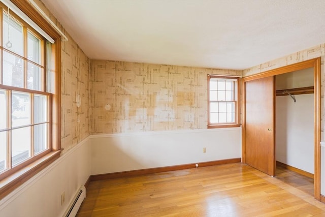 28 Marks Rd, Weymouth, MA 02189 - unfurnished bedroom featuring wood finished floors, a closet, baseboards, a baseboard heating unit, and wallpapered walls