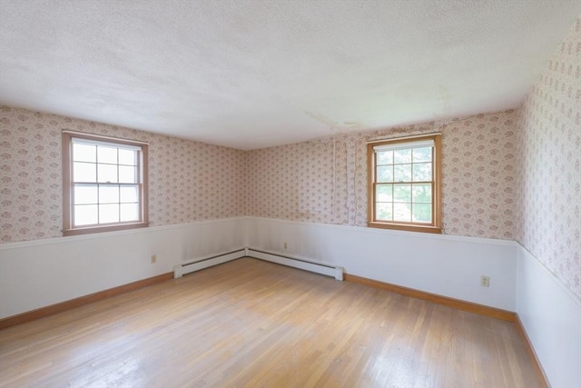 28 Marks Rd, Weymouth, MA 02189 - spare room with plenty of natural light, a textured ceiling, wood finished floors, and a baseboard heating unit
