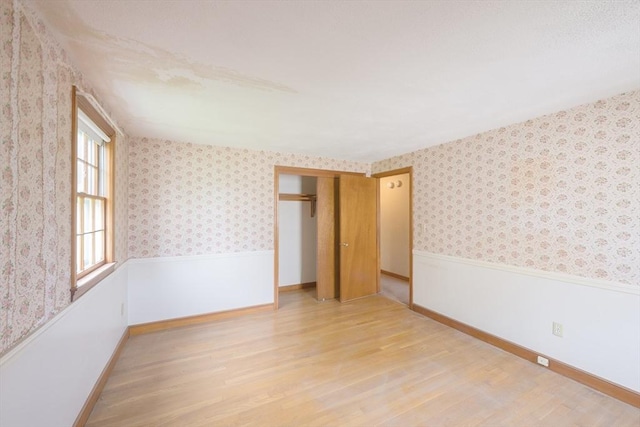28 Marks Rd, Weymouth, MA 02189 - unfurnished room with light wood-type flooring, wallpapered walls, a wainscoted wall, and baseboards