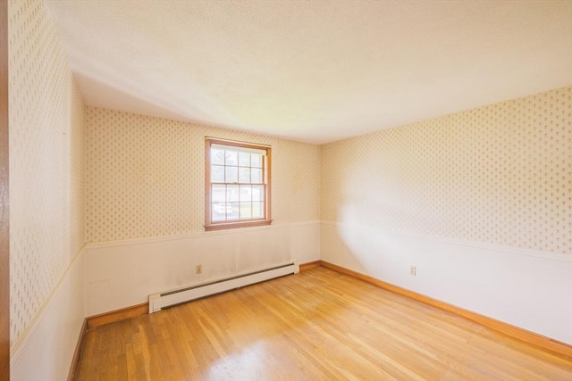 28 Marks Rd, Weymouth, MA 02189 - spare room featuring a baseboard heating unit, light wood-style floors, wallpapered walls, and baseboards