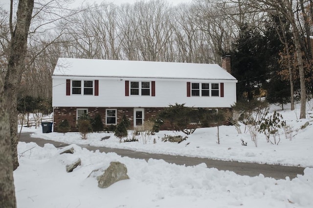 view of front of property with a chimney and brick siding