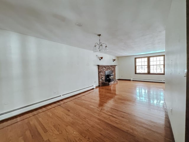 unfurnished living room featuring light wood-type flooring, a baseboard radiator, and a notable chandelier