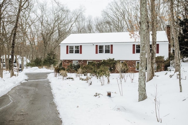 view of front of property with a chimney and brick siding