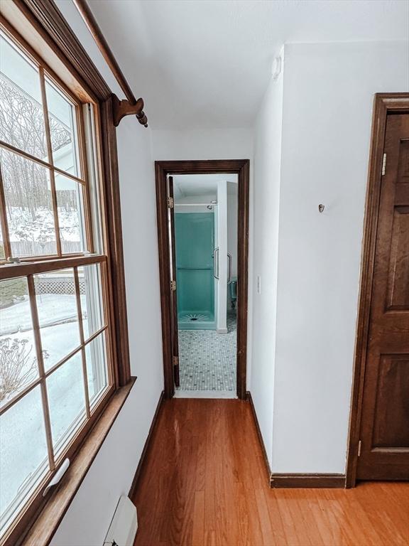 hallway with light wood finished floors and baseboards