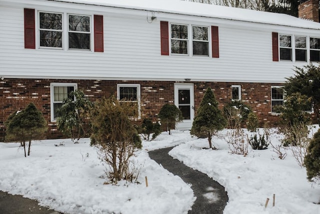 view of front of home featuring brick siding and a chimney