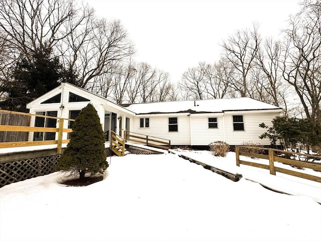 snow covered property with fence and a wooden deck