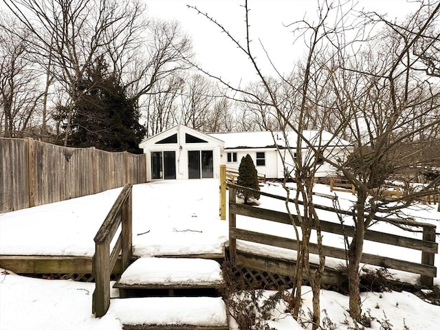 snow covered deck featuring fence