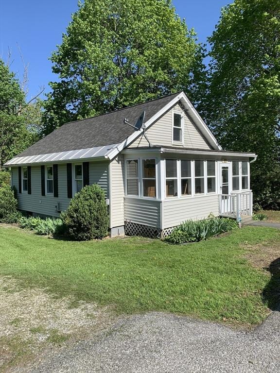 23 A St, North Adams, MA 01220 - view of front of house featuring a front yard, roof with shingles, and a sunroom