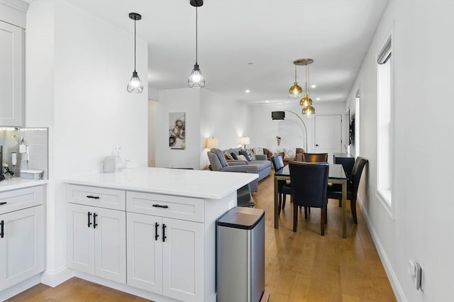9 Boston St Unit 3, Salem, MA 01970 - kitchen with a peninsula, decorative backsplash, open floor plan, light wood-type flooring, and light countertops