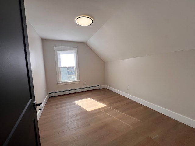 bonus room with light hardwood / wood-style flooring, vaulted ceiling, and a baseboard radiator