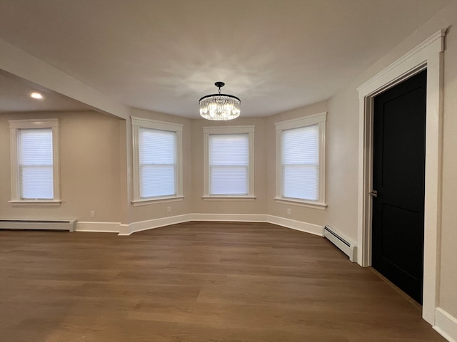 unfurnished dining area with dark wood-type flooring, a healthy amount of sunlight, and a baseboard radiator