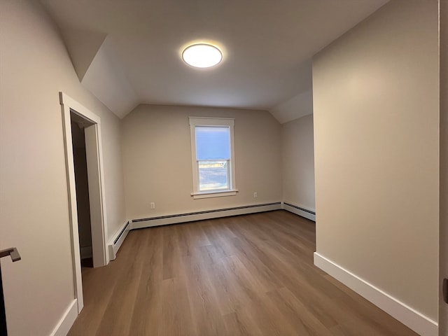 additional living space with light hardwood / wood-style floors, lofted ceiling, and a baseboard radiator