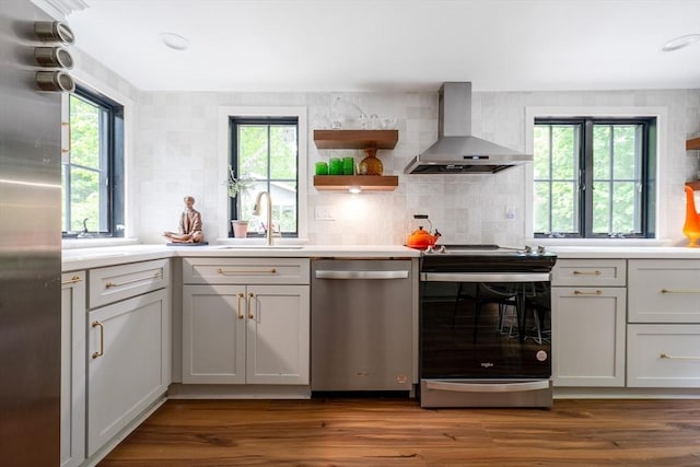 32 Fern St, Concord, MA 01742 - kitchen featuring stainless steel appliances, wall chimney range hood, a sink, and plenty of natural light