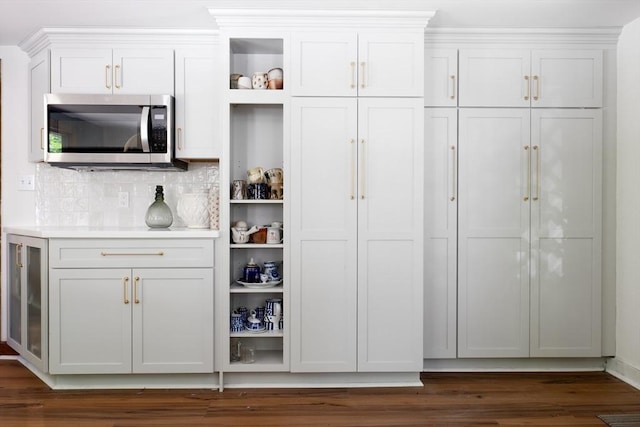 32 Fern St, Concord, MA 01742 - interior space featuring stainless steel microwave, open shelves, white cabinets, dark wood-style floors, and backsplash
