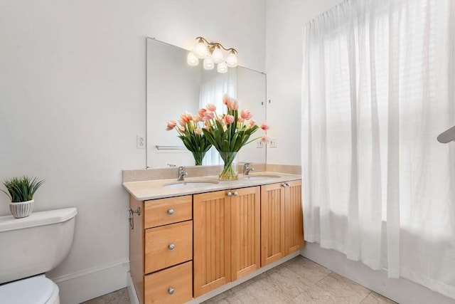 bathroom with double vanity, toilet, shower / tub combination, and a sink