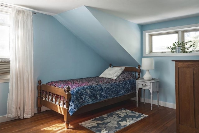 bedroom featuring baseboards, wood finished floors, and lofted ceiling