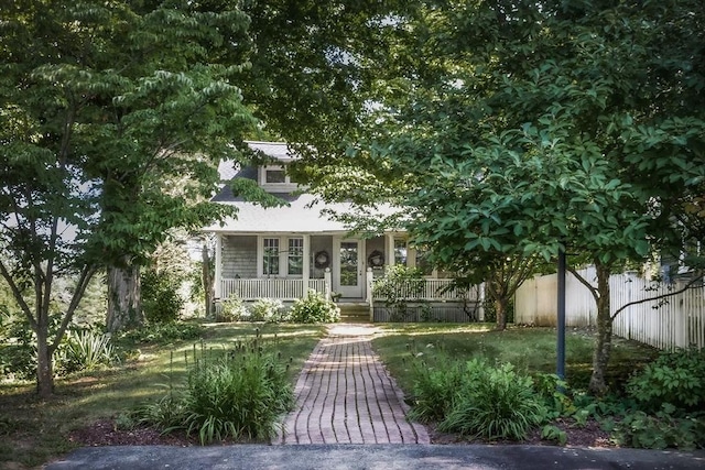 view of front facade featuring fence and covered porch