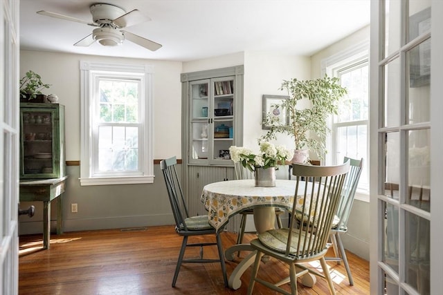 dining space with ceiling fan, visible vents, plenty of natural light, and wood finished floors