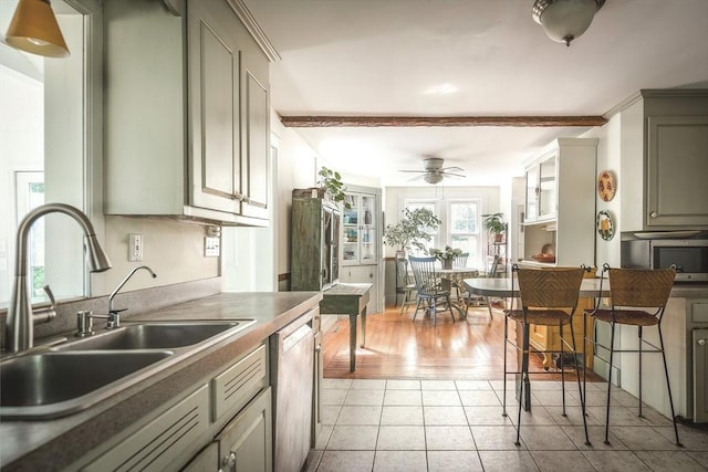 kitchen featuring ceiling fan, a sink, light tile patterned floors, stainless steel microwave, and dishwashing machine