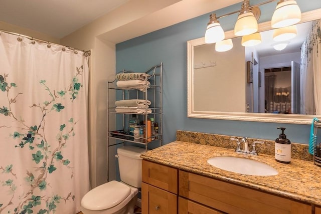 bathroom featuring walk in shower, vanity, and toilet