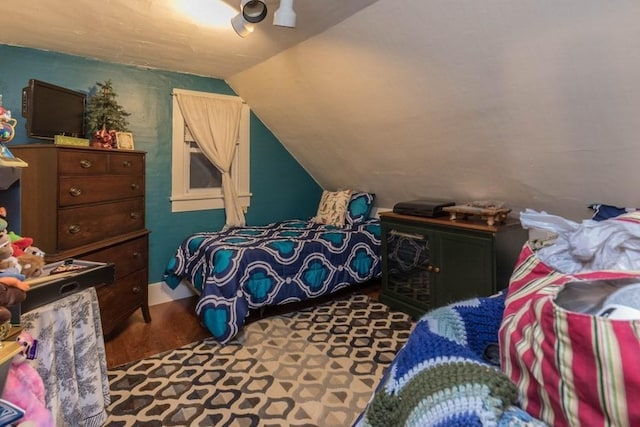 bedroom with hardwood / wood-style flooring and lofted ceiling