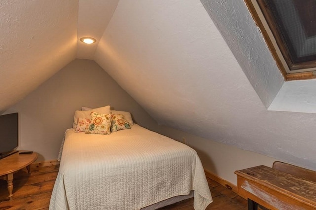 bedroom featuring wood-type flooring and vaulted ceiling