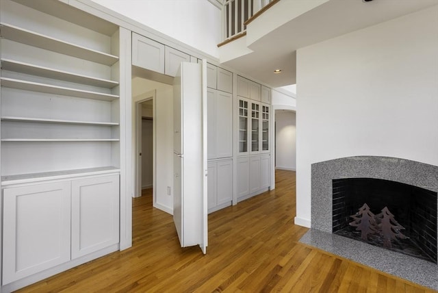 240 Atlantic Rd, Gloucester, MA 01930 - unfurnished living room with light wood-type flooring, a fireplace with flush hearth, built in shelves, baseboards, and recessed lighting