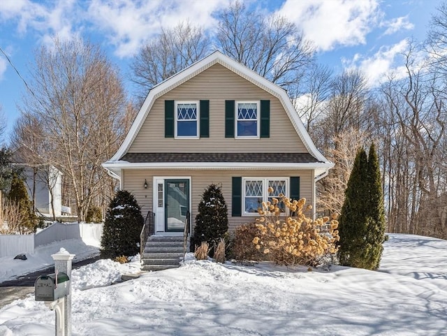 dutch colonial featuring roof with shingles, fence, and a gambrel roof