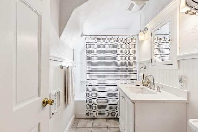 bathroom featuring toilet, a shower with shower curtain, wainscoting, vanity, and tile patterned floors