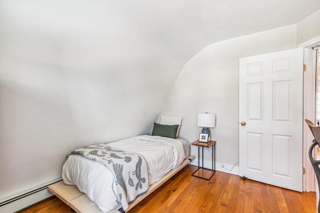 bedroom featuring a baseboard heating unit and light wood finished floors