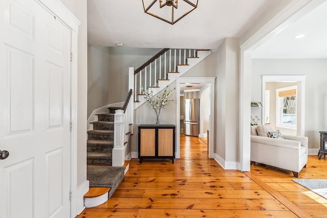 entryway with stairway, baseboards, and hardwood / wood-style flooring