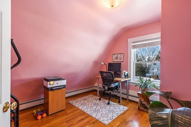 office area with a baseboard heating unit, vaulted ceiling, and wood finished floors