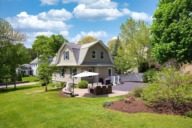 back of property featuring an outdoor hangout area, fence, a gambrel roof, a yard, and a patio area