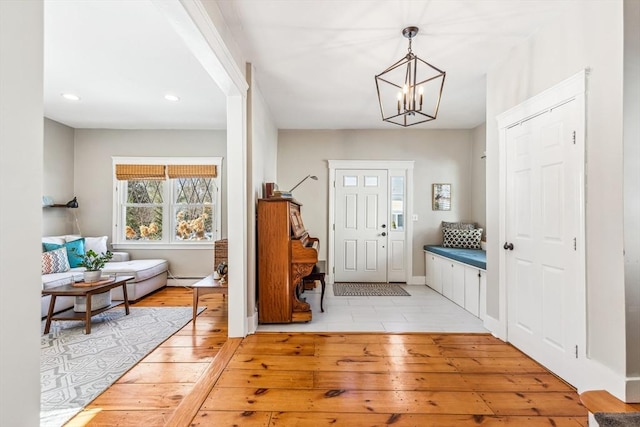 foyer featuring light wood finished floors, baseboards, a baseboard radiator, a chandelier, and recessed lighting