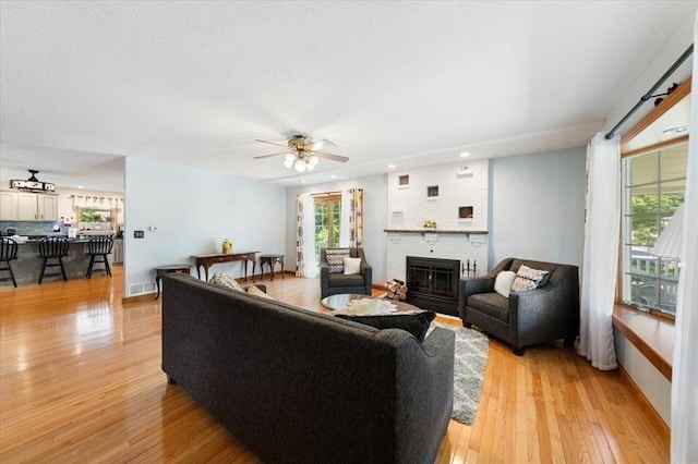 472 Potter Rd, Framingham, MA 01701 - living room with light wood finished floors, recessed lighting, a brick fireplace, and a ceiling fan