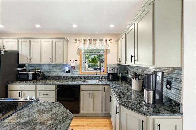 472 Potter Rd, Framingham, MA 01701 - kitchen with black appliances, dark stone countertops, backsplash, light wood-style floors, and recessed lighting