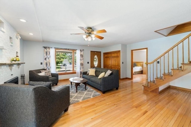 472 Potter Rd, Framingham, MA 01701 - living area with light wood finished floors, a ceiling fan, stairs, a brick fireplace, and recessed lighting