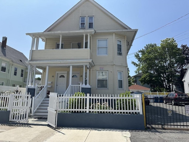89-91 Cambridge St, Lawrence, MA 01843 - view of front facade featuring covered porch, a balcony, a fenced front yard, and a gate