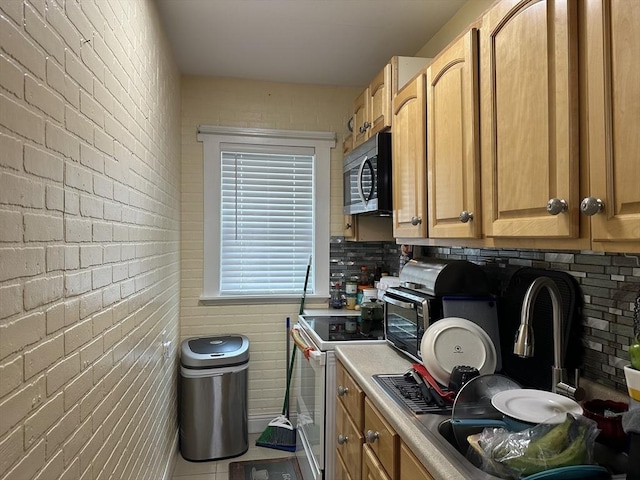 89-91 Cambridge St, Lawrence, MA 01843 - kitchen with stainless steel microwave, white electric range, light countertops, and brick wall