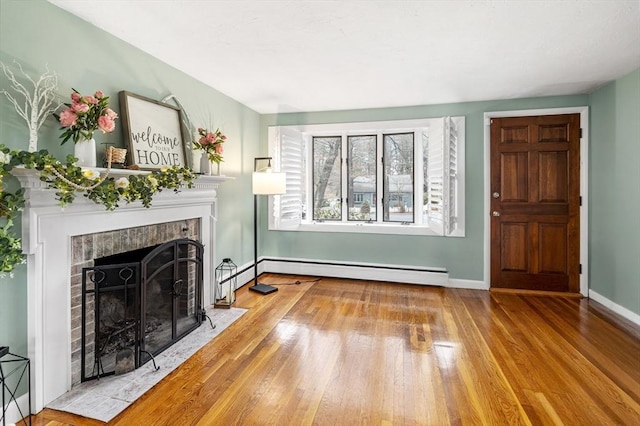 unfurnished living room featuring baseboards, a fireplace with flush hearth, baseboard heating, and wood finished floors